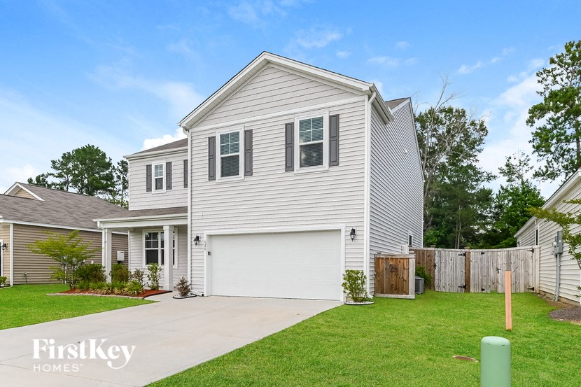 a white house with a white garage door and a lawn