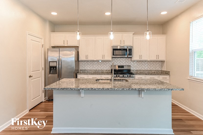 a kitchen with white cabinets and a granite counter top