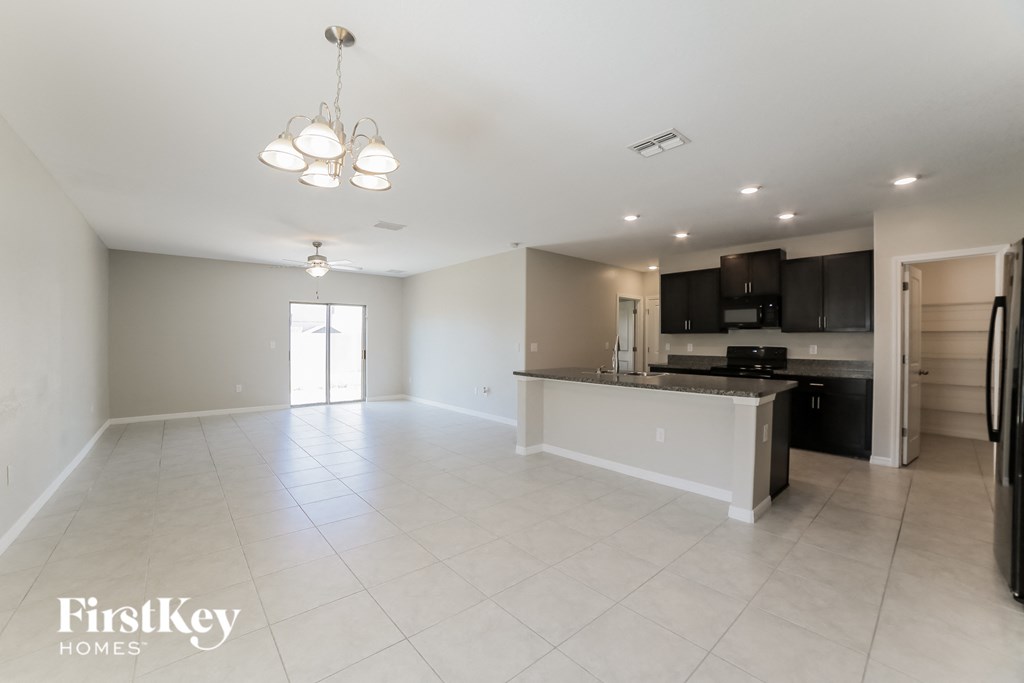 A spacious kitchen with a refrigerator, cabinets, and a countertop.