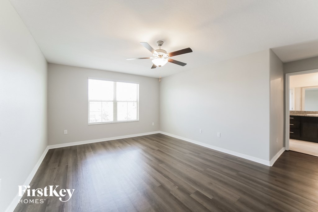 A spacious room with a ceiling fan and a window.