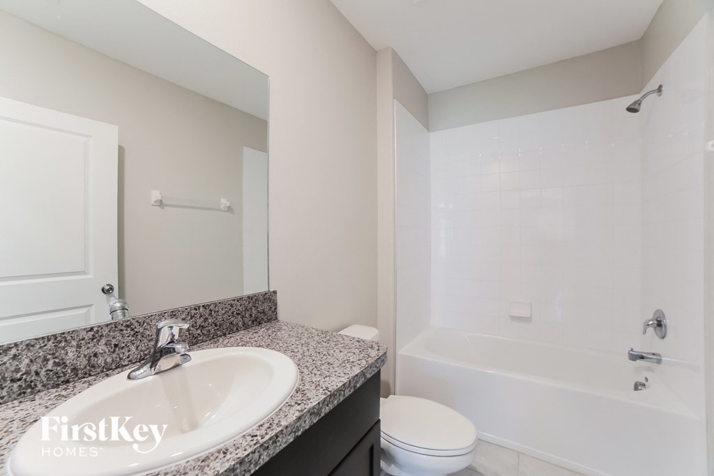 A bathroom with a sink, toilet, and bathtub.