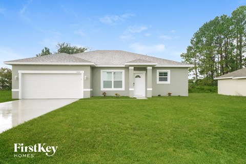 the exterior of a home with a green lawn and a white house