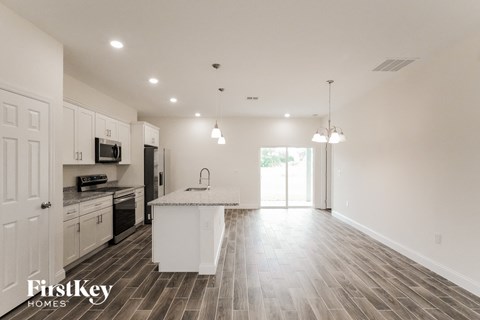 an open kitchen and living room with a marble counter top