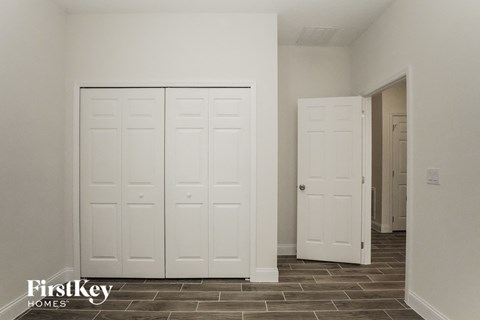 a bedroom with two closets and a door to a hallway