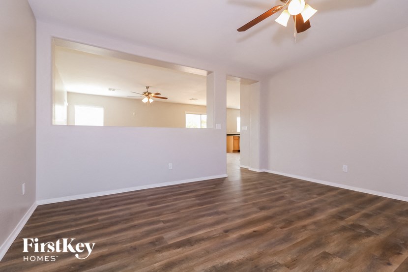 A room with wooden flooring and a ceiling fan.