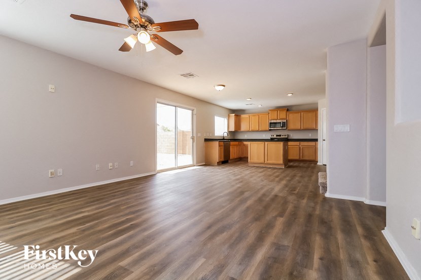 A spacious room with a ceiling fan and wooden flooring.
