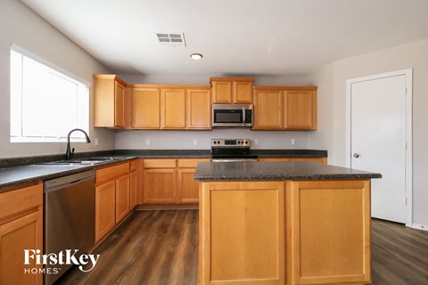 A kitchen with wooden cabinets and a black countertop.