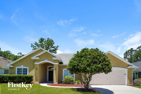a beige house with a tree in front of it