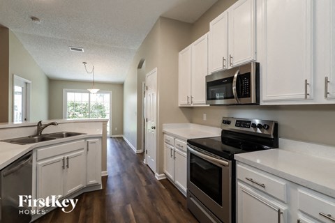 a kitchen with white cabinets and black appliances