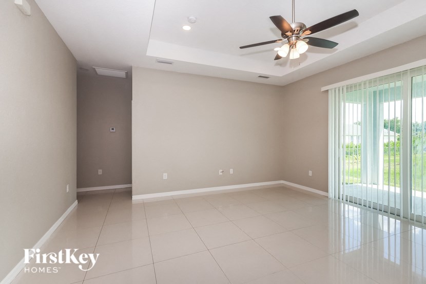 an empty living room with a ceiling fan