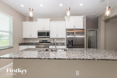 a kitchen with white cabinets and granite counter tops