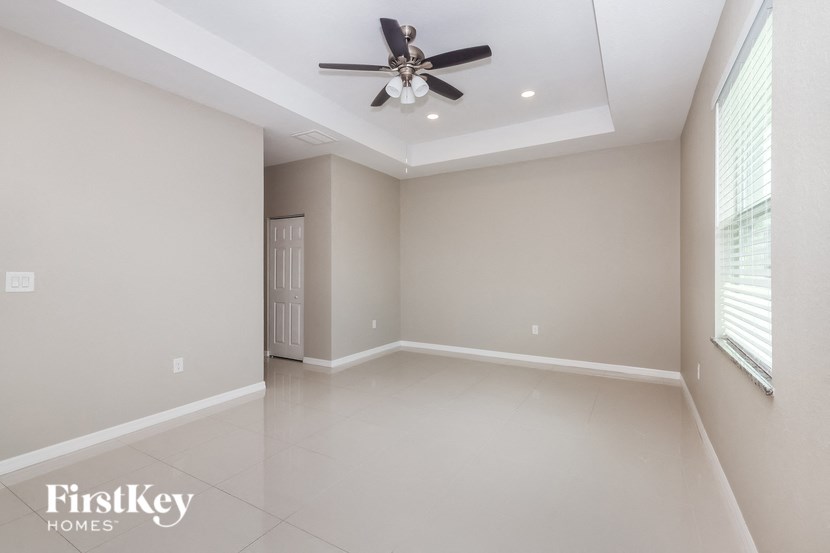 an empty living room with a ceiling fan