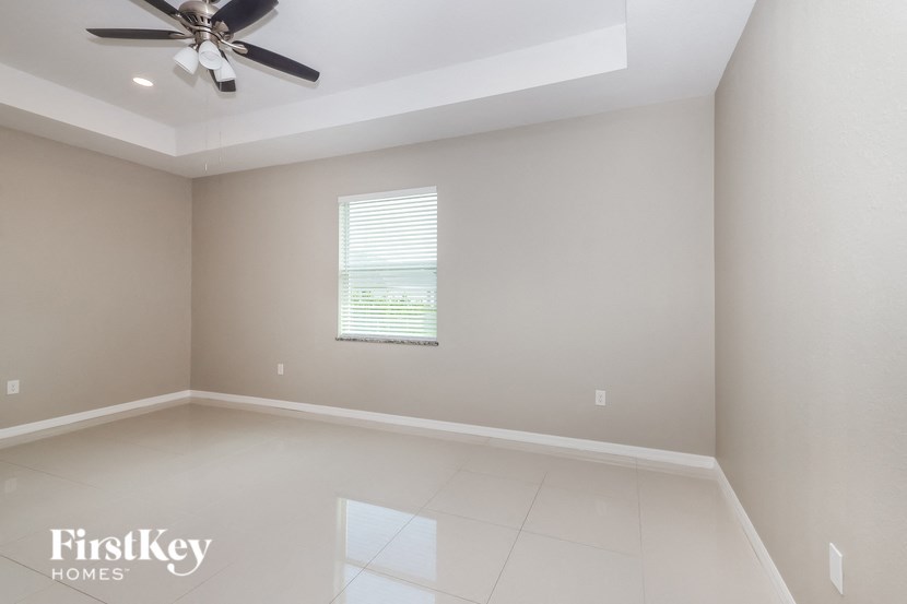 a empty room with a ceiling fan and a window