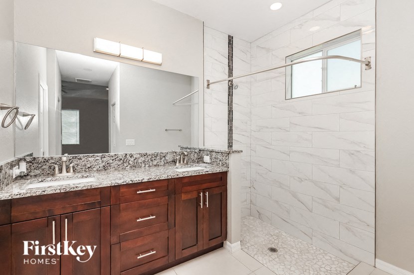 two sinks in a bathroom with a shower and a mirror