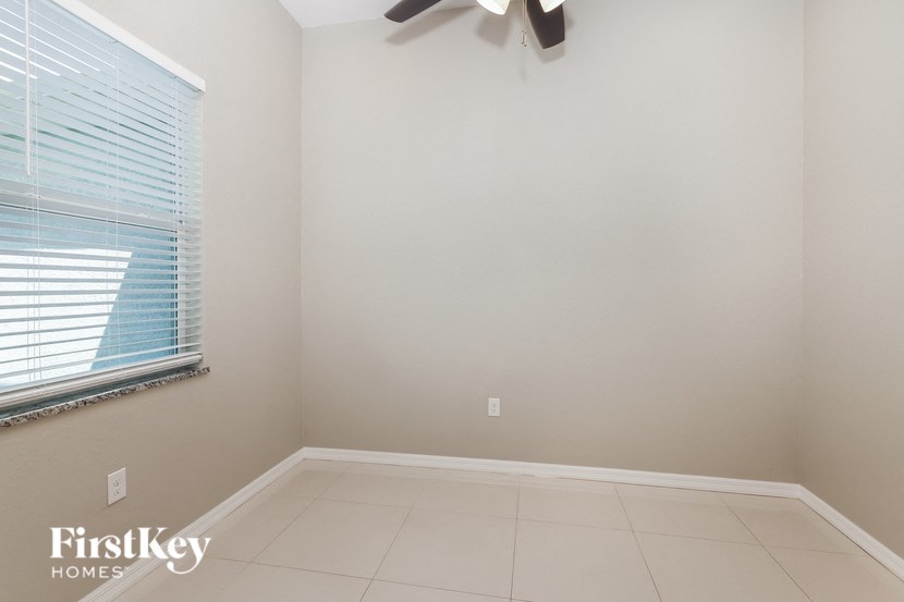 an empty room with a window and a ceiling fan