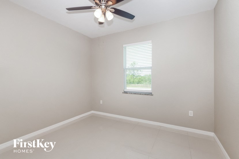 a empty room with a ceiling fan and a window