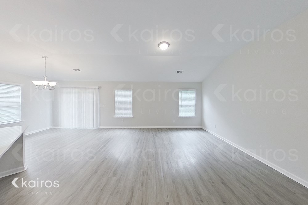 an empty living room with white walls and wood floors