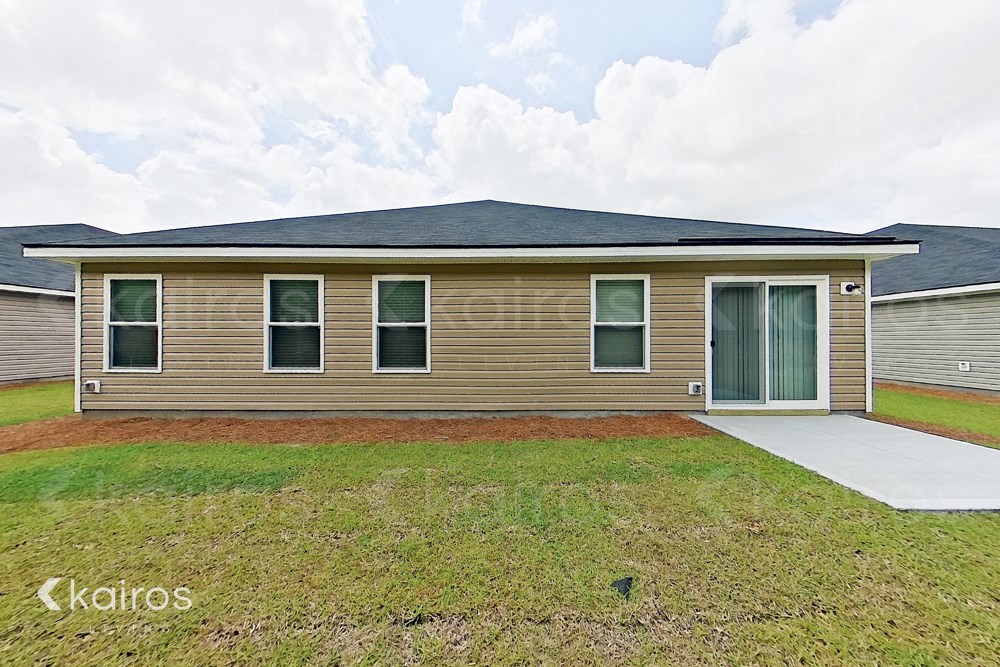 a small brown house with a yard and a garage