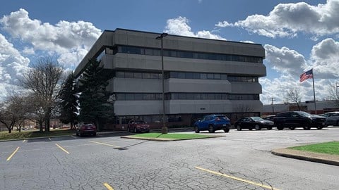 an office building with cars parked in a parking lot