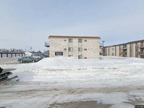 A building with a sign that says "LARK" in front of a parking lot.