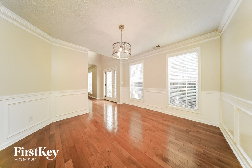 an empty living room with wood floors and white walls