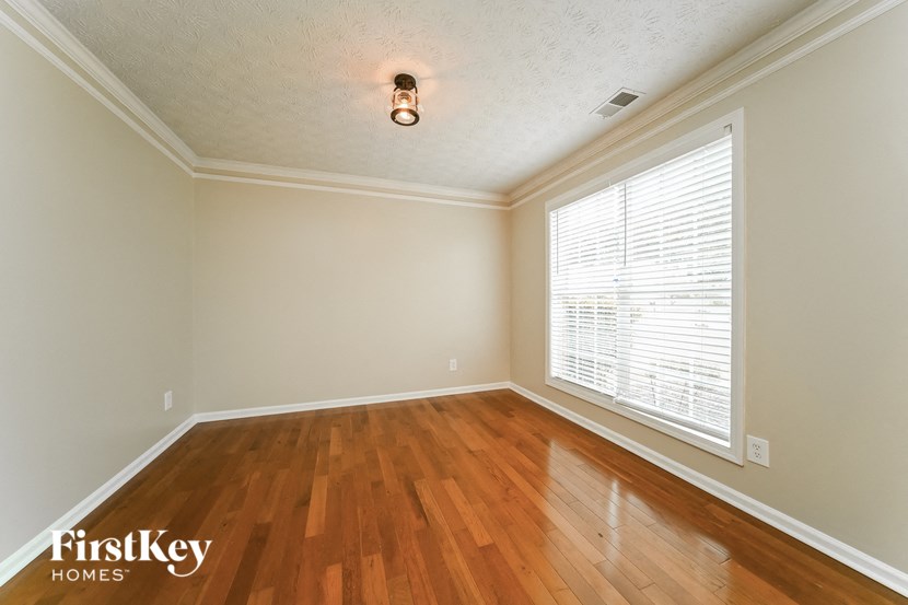 the living room with wood floors and a large window