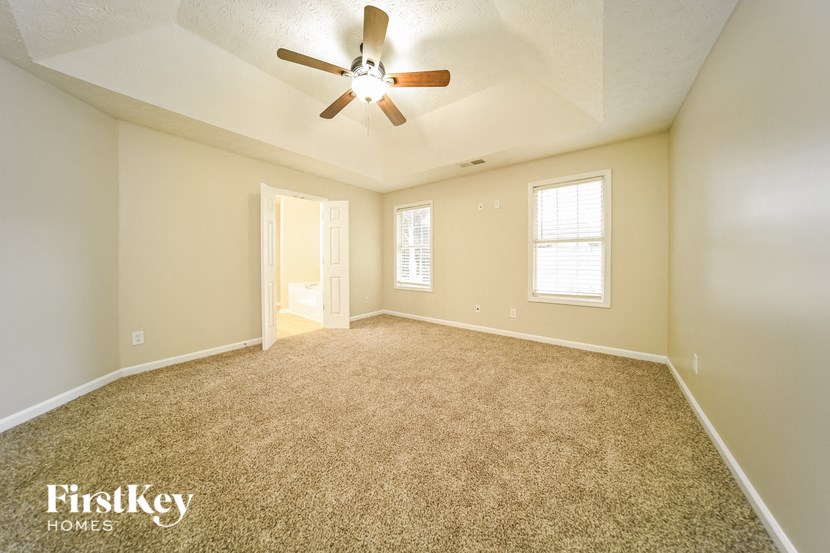 an empty living room with a ceiling fan