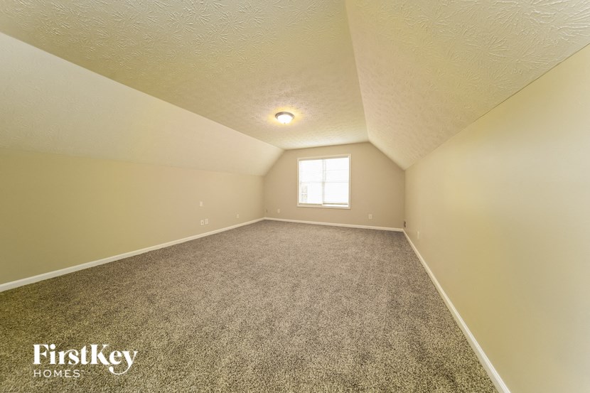 the upstairs bonus room has carpet and a window