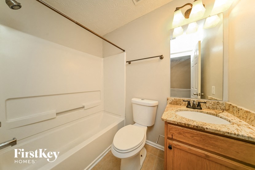 a bathroom with a toilet and a sink and a bath tub