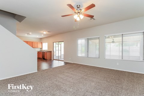 A spacious room with a ceiling fan and carpeted floor.