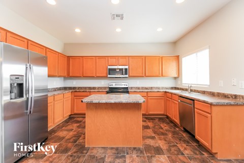 A kitchen with orange cabinets and a wooden island.