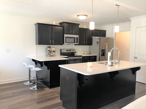 a kitchen with black cabinets and a white counter top
