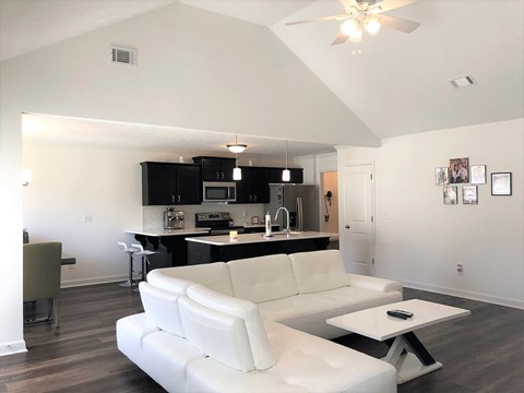 a living room with a white couch and a kitchen