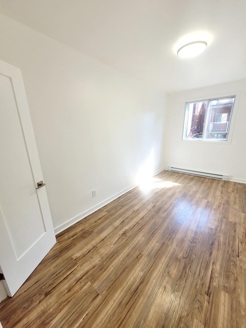 a living room with wood flooring and a window