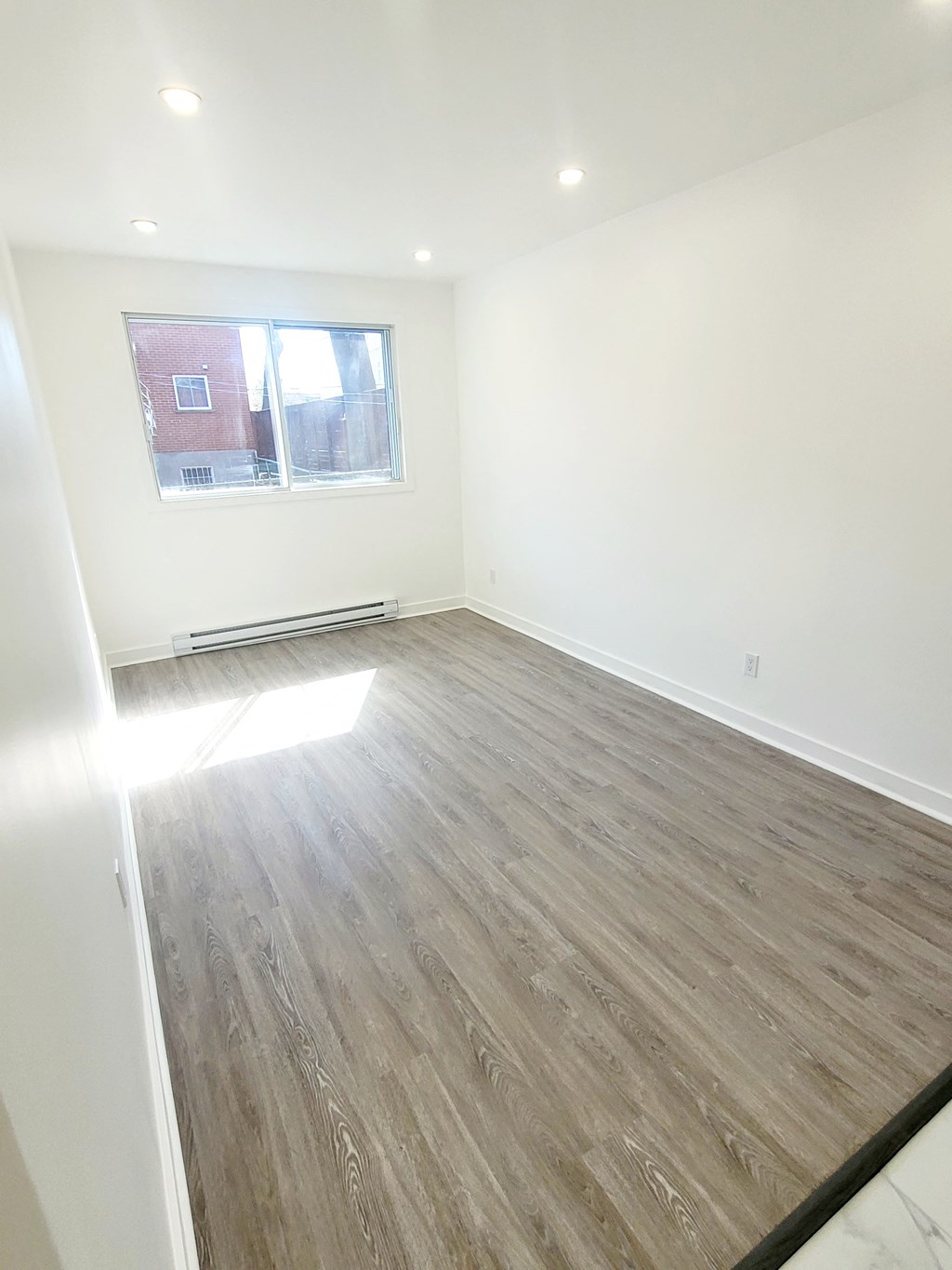 an empty room with white walls and a window