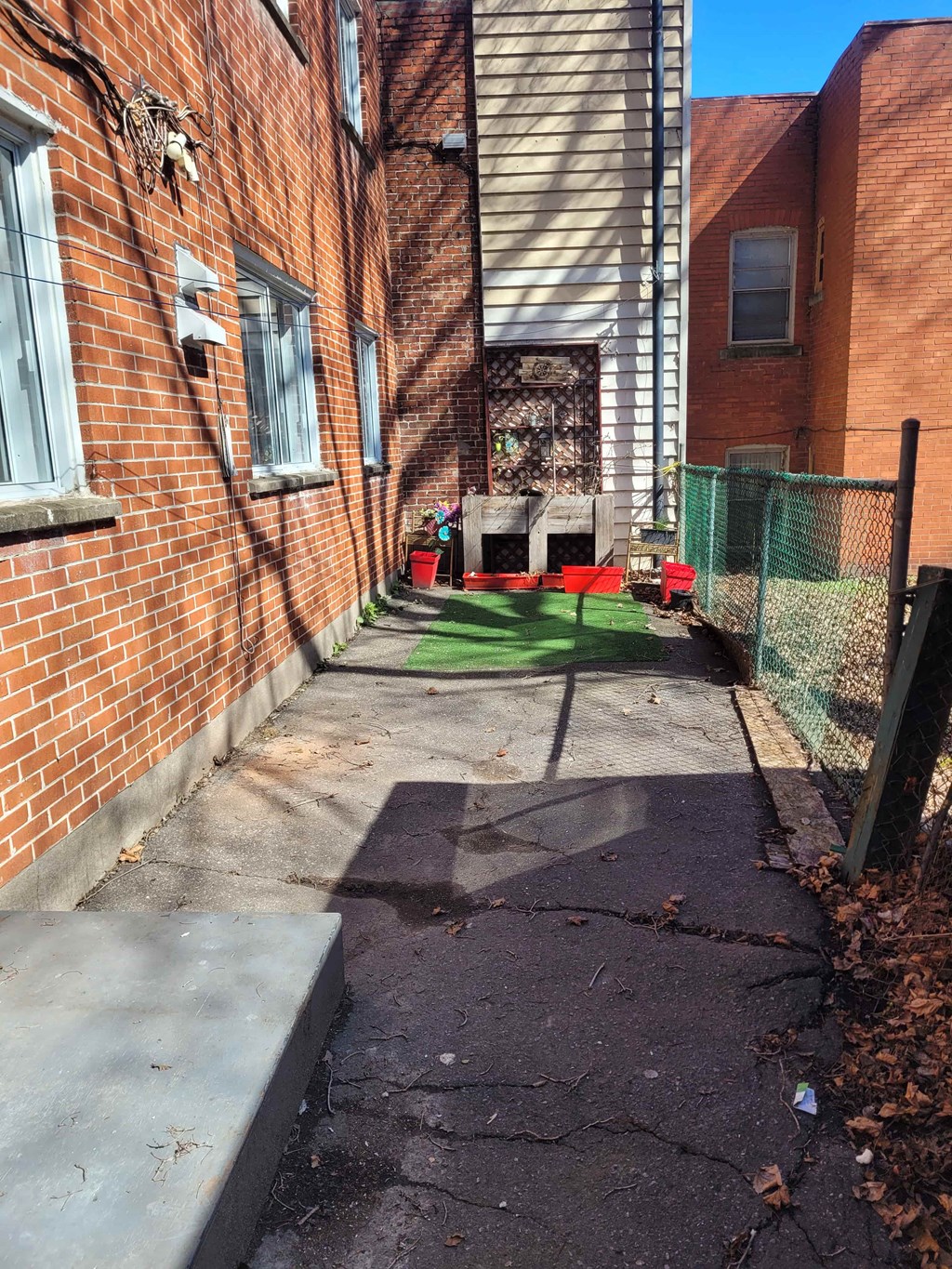 a yard with green grass in front of a brick building