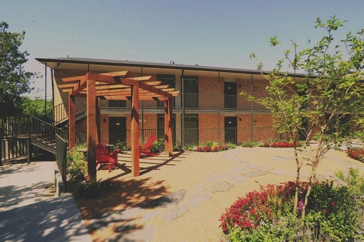 a building with a patio and red chairs