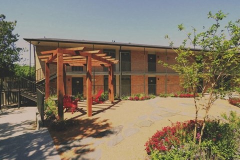 a building with a patio and red chairs