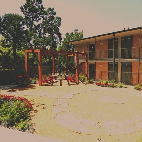 a playground with a swing set in front of a building