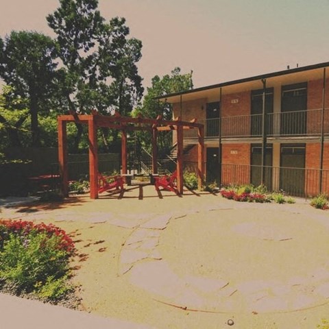 a playground with a swing set in front of a building