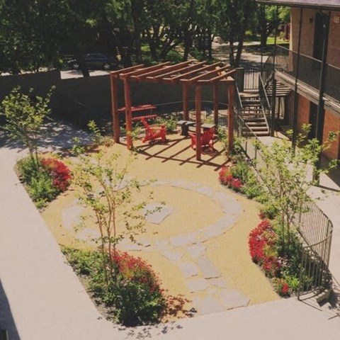 a courtyard with a seating area and a wooden structure