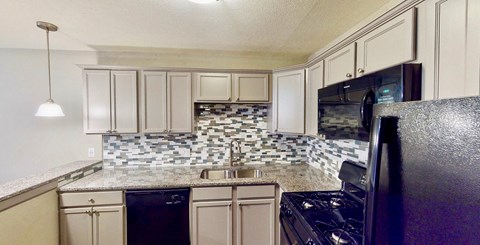 a kitchen with white cabinets and black appliances