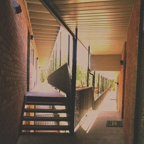 a long corridor with stairs and a building