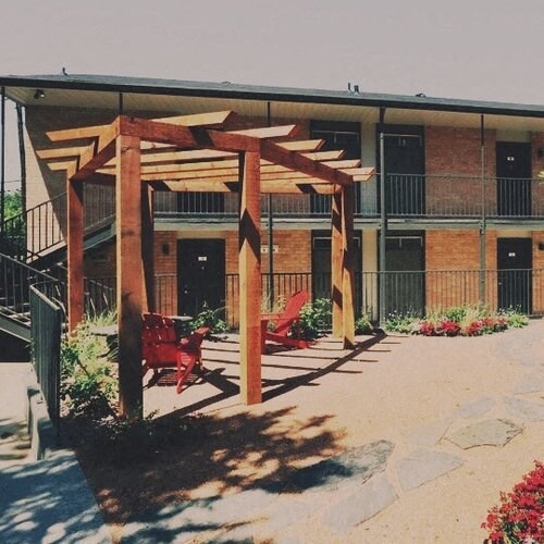 a building with a patio with red chairs