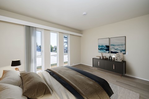 A bedroom with a large bed and a painting on the wall.