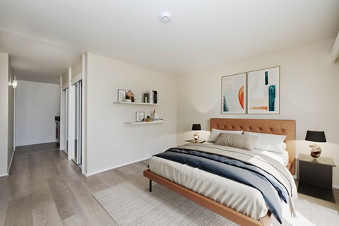 A bedroom with a bed, nightstands, and a painting on the wall.