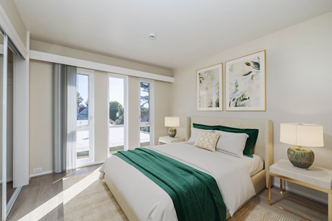 A bedroom with a large bed and a green blanket.