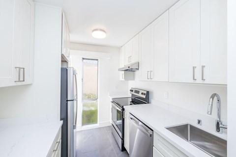 A kitchen with white cabinets and stainless steel appliances.