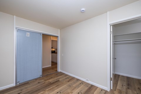 A room with a white door and a wooden floor.
