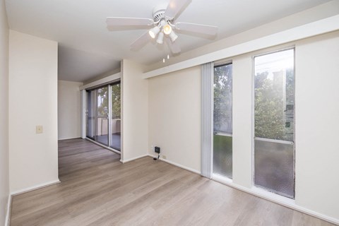 a living room with sliding glass doors and a ceiling fan